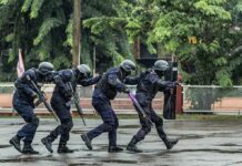 What Do We Know About Omar’s Federal Probe? Police tactical team advancing in rain