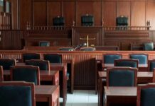 Secrecy Crushed in Chilling NY Case Empty courtroom with wooden benches and judge's bench