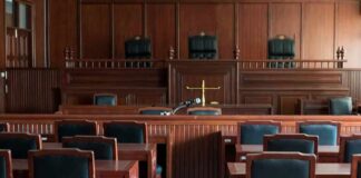 Secrecy Crushed in Chilling NY Case Empty courtroom with wooden benches and judge's bench
