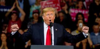 Trump’s Price Tag For Fetterman? Donald Trump speaking at a rally podium with arms raised