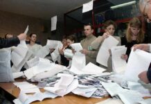 Court Fight Brews Over 20,000 Ballots People counting ballots at a table