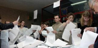 Court Fight Brews Over 20,000 Ballots People counting ballots at a table