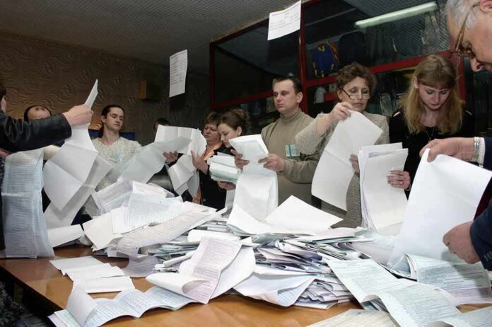 shutterstock_1208093 People counting ballots at a table
