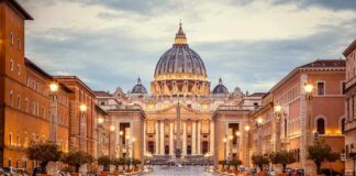 Rome Hospital Braces For Papal Operation St. Peter's Basilica at the end of a wet street at dusk