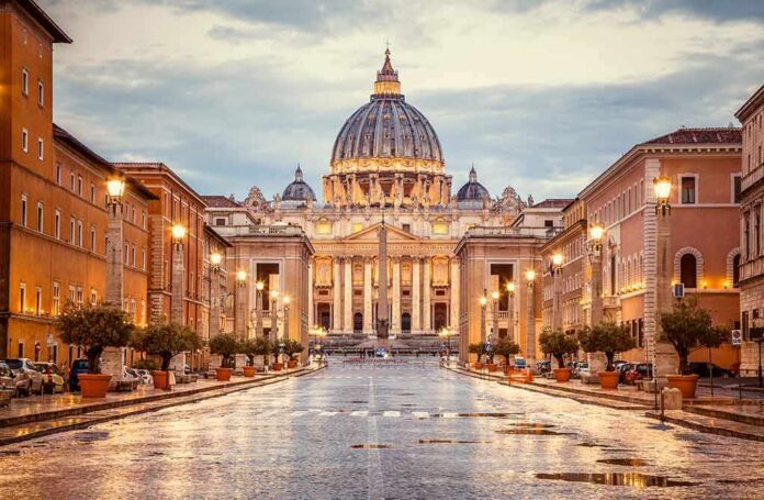 shutterstock_1218983827 St. Peter's Basilica at the end of a wet street at dusk