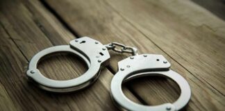 Foreign Agent Hunt Ends at LAX Metal handcuffs on wooden surface
