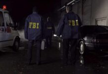 FBI Raids Expose Trafficking Factories FBI agents at a nighttime crime scene beside ambulance and car