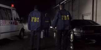 FBI Raids Expose Trafficking Factories FBI agents at a nighttime crime scene beside ambulance and car