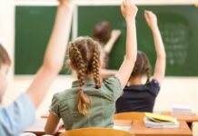 NYC Cover-Up? Over 16,000 Teachers Gone! students raising hands in a classroom