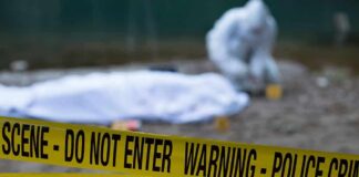 Crime scene with police tape and forensic investigator