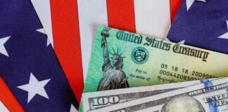 Budget Cliff Dodge Or Permanent Squeeze? U.S. Treasury check and hundred dollar bills on American flag
