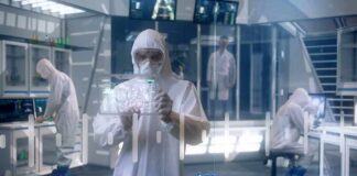 Deadly Pneumonia Triggers Quarantines Scientist in hazmat suit using a transparent digital tablet in a lab