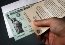Hand holding IRS letter with U.S. Treasury check