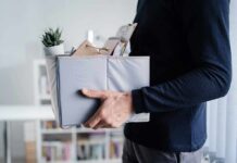 Big Tech Gut-Punch Hits Netflix Person carrying a box of office items