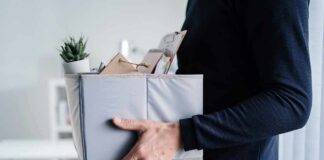 Big Tech Gut-Punch Hits Netflix Person carrying a box of office items