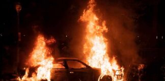 Burning car engulfed in flames at night
