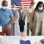 Voters wearing masks stand in line at a polling station