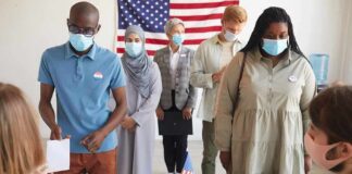 Nine States Shielded From DHS Voter Sweeps Voters wearing masks stand in line at a polling station