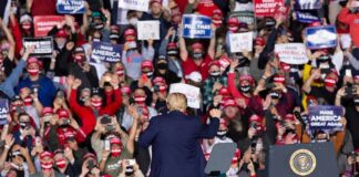 Rally Bombshell Targets Senate Contender Crowd at a political rally with speaker on stage; Dontrelle Inman present in the audience