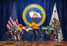 Newsom’s Power Play Tests Washington Press microphones at a podium before California governor seal