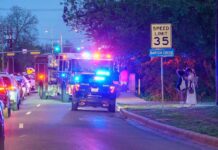 Gunfire Shocks Packed Homecoming Emergency vehicles with flashing lights on a city street at night