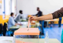 Ottawa’s Worst Fear Put On Ice Hand casting ballot into a box at a polling station