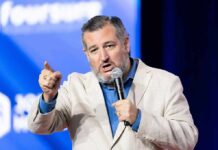 Cruz’s El-Sayed Slur Ignites Firestorm man speaking into microphone on stage