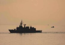 Twin Sinkings Jolt Hormuz naval ship silhouette at sea during sunset