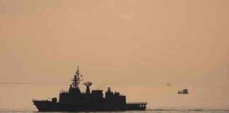 Twin Sinkings Jolt Hormuz naval ship silhouette at sea during sunset