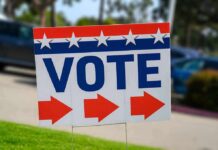Election sign with the word VOTE and red arrows