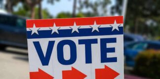Election sign with the word VOTE and red arrows