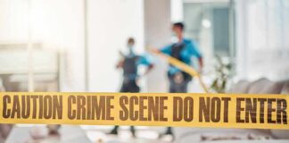 Probable Cause Hits University Frat crime scene tape in a living room with two officers in background