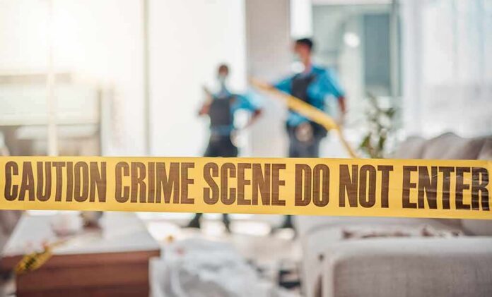 shutterstock_2329488061 crime scene tape in a living room with two officers in background