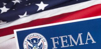 Isaias Looms: FEMA Money Unlocked Fast FEMA sign with U.S. flag background