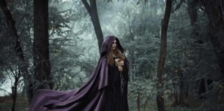 Witchcraft Organizers Plan to Protest Univ of Oregon Speaker Woman in a flowing purple cloak holding a book in a misty forest