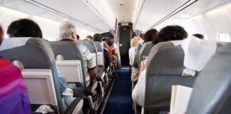 Airplane cabin with passengers seated in rows
