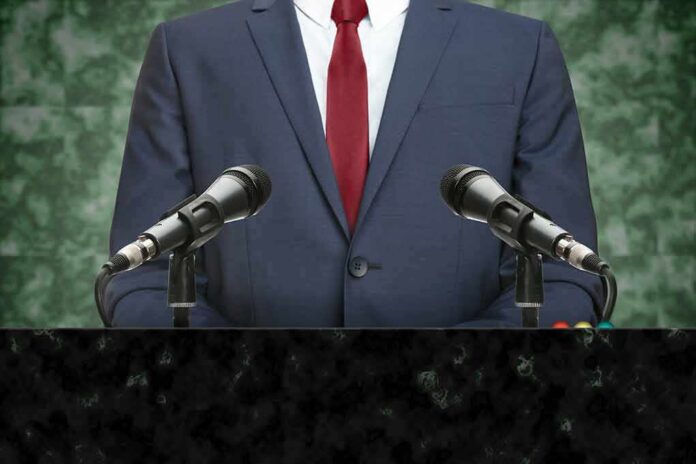 shutterstock_723402049 speaker at podium with microphones