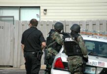Nine Dead After Pennsylvania Home Shooting police officers in tactical gear beside patrol car
