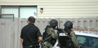 Nine Dead After Pennsylvania Home Shooting police officers in tactical gear beside patrol car